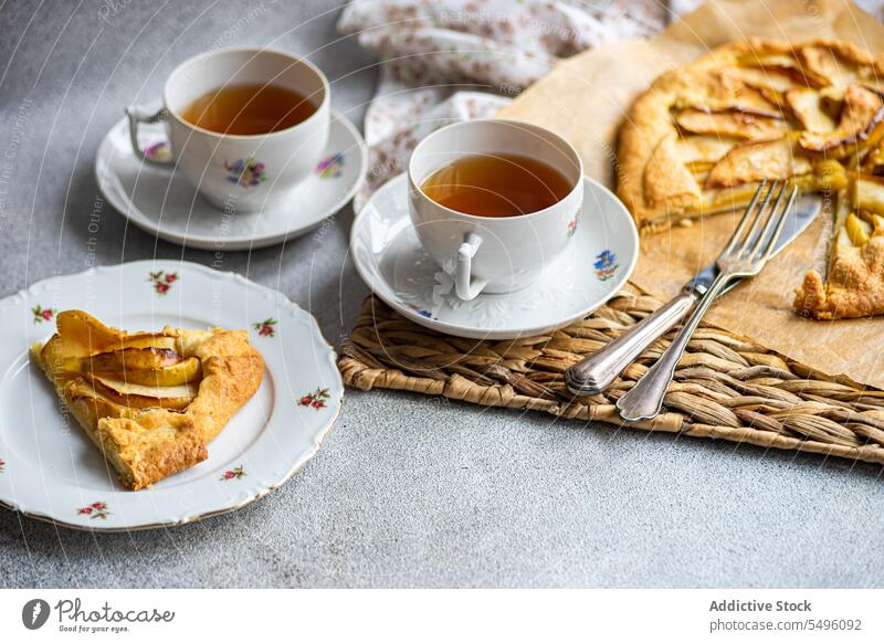 Apfelgalette und Tee auf dem modernen Betontisch Pasteten Spielfigur Galette Tasse Teetasse rustikal Tablett grau Tisch Lebensmittel trinken Getränk liquide