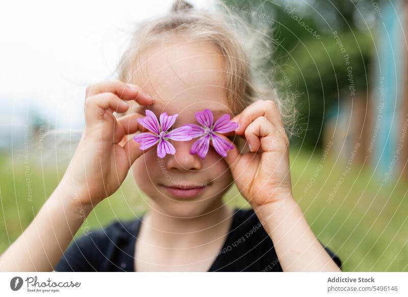 Kleines Mädchen mit kleinen Blumen Kind Sommer purpur Porträt Augen abdecken wenig filigran niedlich Malve bezaubernd unschuldig frisch Natur Kindheit sanft