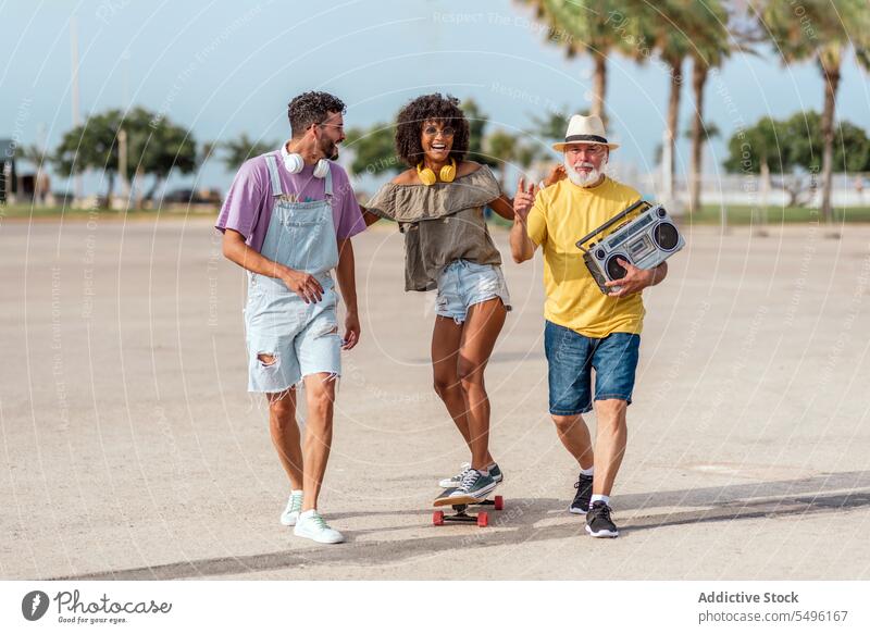 Glückliche Familie auf der Straße mit Skateboard Mitfahrgelegenheit Lachen Musik Spaß haben positiv vielfältig Skater aufgeregt genießen Aktivität Energie