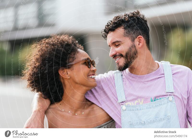 Fröhliches multiethnisches Paar, das sich auf einer Straße in der Stadt umarmt Mann Frau Spaziergang Lächeln Glück Umarmung Partnerschaft heiter Zusammensein