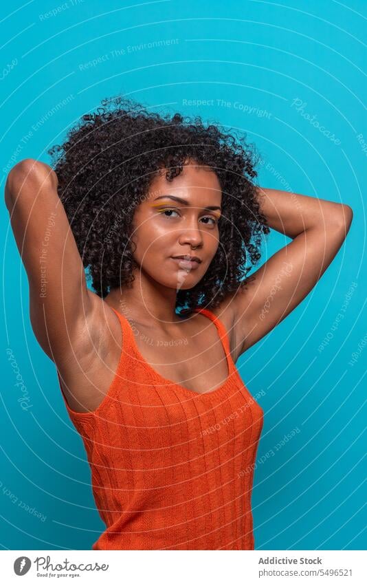 Schlanke schwarze Frau in orangefarbenem Top Mode Model schlank schlanke dunkles Haar krause Haare Porträt Afroamerikaner Outfit Stoff anhaben lässig brünett