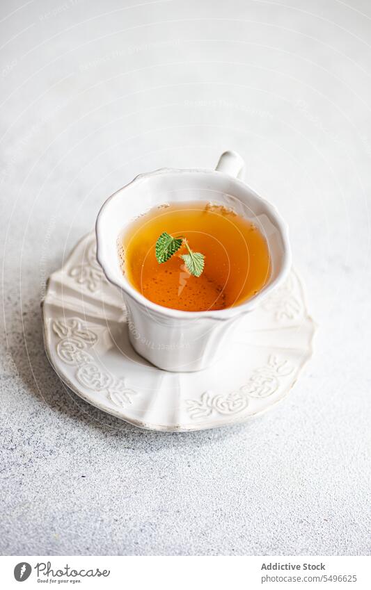 Blütentee mit frischen Kräutern Tee geblümt Glas Kraut Keramik Teller durchsichtig satt liquide Getränk trinken Gesundheit Entzug natürlich dekorativ Tisch