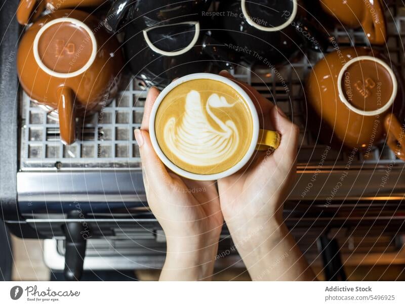 Crop-Frau mit Tasse Milchkaffee Kaffee Latte Heißgetränk aromatisch trinken Becher geschmackvoll Maschine Koffein Küche Frühstück Aroma lecker Energie frisch