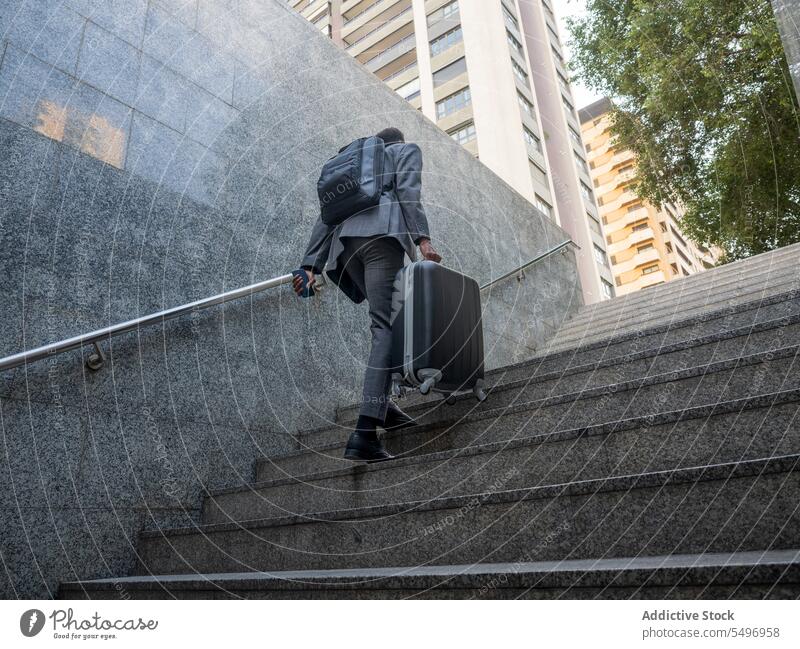 Anonymer schwarzer Mann mit Koffer geht eine Treppe hinauf nach oben unterirdisch formal Spaziergang Treppenhaus Geschäftsmann männlich reisen Gepäck