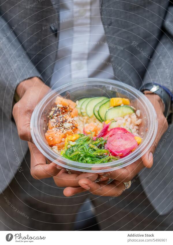 Unbekannter Mann zeigt Schüssel mit Salat im Tageslicht Salatbeilage Gemüse Fisch gesunde Ernährung Schalen & Schüsseln Salatgurke zeigen Tomate Diät Scheibe