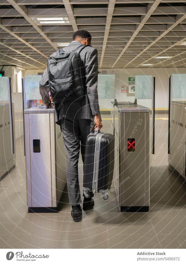 Schwarzer Geschäftsmann mit Gepäck in der U-Bahn Fußgänger Koffer unterirdisch Pass Postkarte Tourniquet männlich schwarz Afroamerikaner Unternehmer Passagier