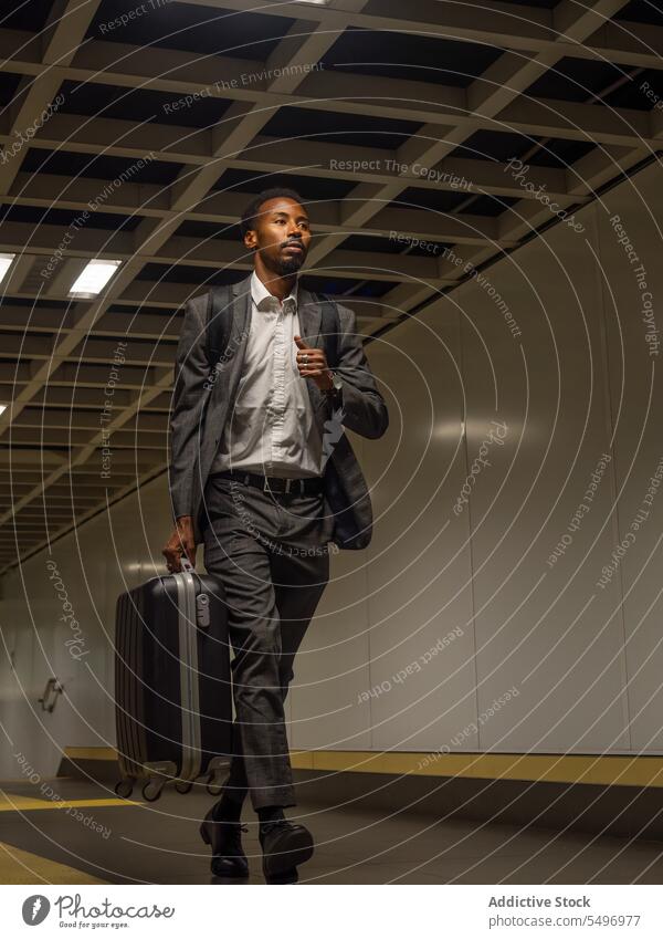 Nachdenklicher schwarzer Geschäftsmann mit Koffer im Gehen Unternehmer reisen Tasche führen Rucksack Spaziergang schlendern nachdenken männlich Afroamerikaner