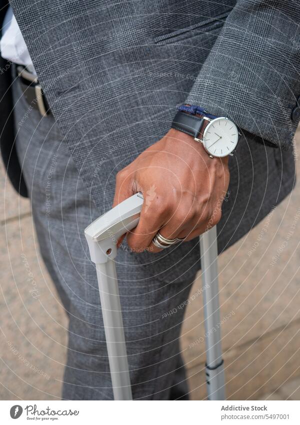 Unbekannter schwarzer Geschäftsmann mit Koffer auf der Straße Arbeitsweg Unternehmer Gepäck Armbanduhr Ausflug Handgriff formal Mann Straßenbelag Spaziergang