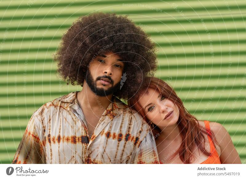 Ein gemischtrassiges Paar steht Rücken an Rücken auf grünem Hintergrund Seelenverwandter Partnerschaft Zuneigung Bonden Freundin Porträt Model Atelier Afro-Look