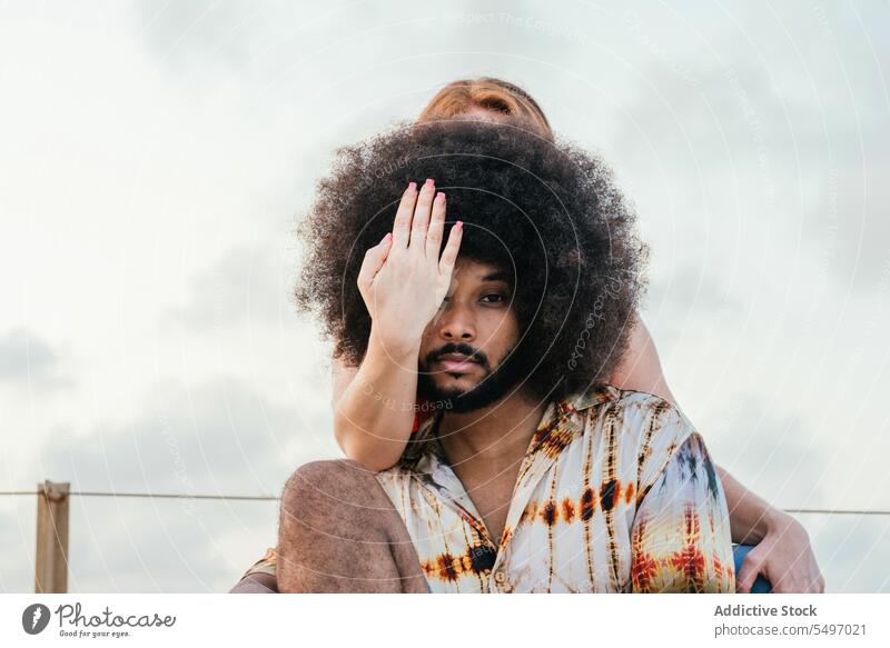 Hand über dem Auge eines schwarzen Mannes mit Afro-Haar Paar Augen abdecken Frisur Zusammensein trendy Freizeit Afro-Look Stil cool ernst Frau krause Haare
