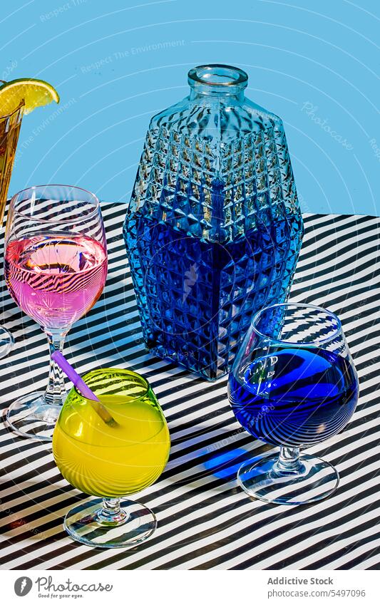 Eine Vielzahl von Gläsern mit verschiedenen Cocktails auf einer gestreiften Oberfläche Getränk trinken blau Glas Zitrone kalt Erfrischung Tee Alkohol farbenfroh