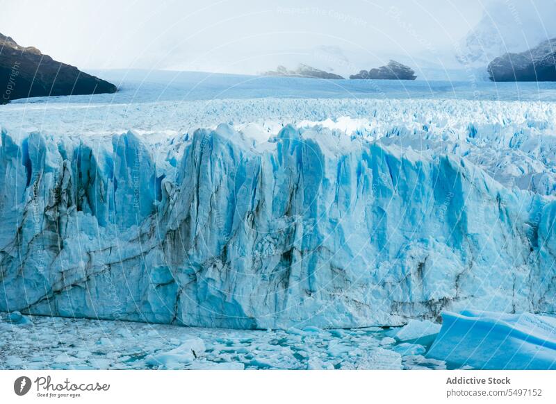 Erstaunliche Aussicht auf einen türkisfarbenen Gletschersee mit Bergen Berge u. Gebirge See gefroren Schnee Winter Eis Eisberg Natur wolkig Wasser malerisch