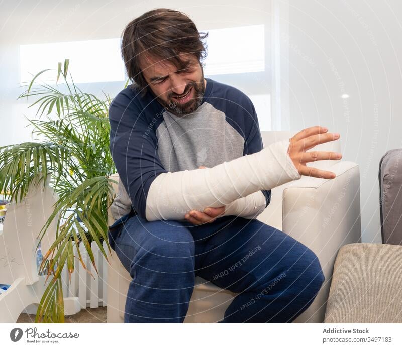 Mann mit Bandagen und Armschmerzen geduldig Schmerz gebrochen Arme Verletzung gießen bandagieren Notfall Krankenhaus männlich physisch orthopädisch Trauma