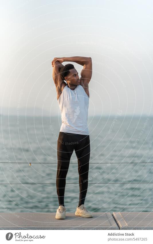 Schwarzer Mann bei Dehnübungen Stauanlage Training Sportler Wegbiegung Barriere Übung Aufwärmen Dehnung männlich Afroamerikaner Aktivität Sportbekleidung