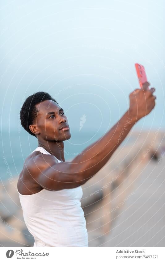 Seriöser schwarzer Mann macht Selfie mit Smartphone Stauanlage MEER positiv Gerät männlich Mobile Apparatur Gedächtnis Telefon fotografieren genießen Optimist