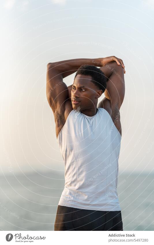 Schwarzer Mann bei Dehnübungen Stauanlage Training Sportler Wegbiegung Barriere Übung Aufwärmen Dehnung männlich Porträt Afroamerikaner Aktivität