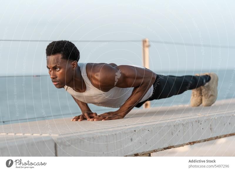 Starker schwarzer Mann macht Plank-Übung auf Brüstung Schiffsplanken Training Bestimmen Sie Athlet Sport Aktivität MEER männlich Ausdauer Afroamerikaner