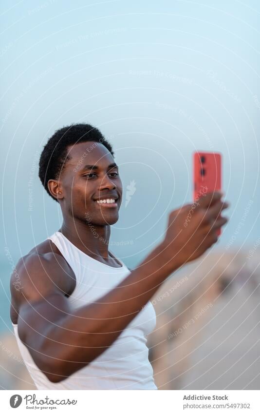 Fröhlicher schwarzer Mann macht Selfie mit Smartphone Glück Stauanlage MEER positiv Lächeln froh Gerät männlich Mobile Apparatur heiter Gedächtnis Telefon