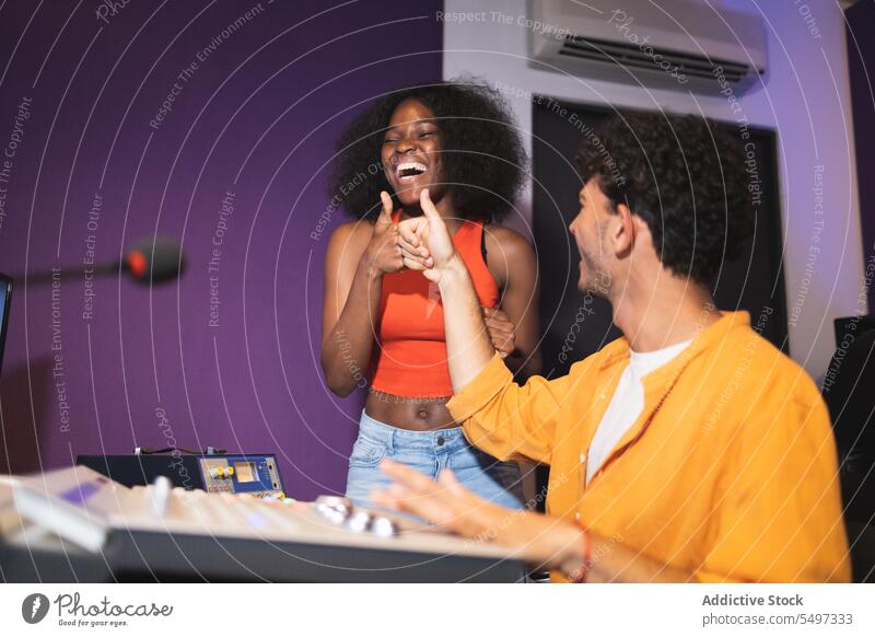 Mann und schwarze Frau genehmigen eine Tonaufnahme Audio Ingenieur Aufzeichnen Sängerin Gesang Klang Musik Atelier mögen Afroamerikaner Künstlerin Stimme