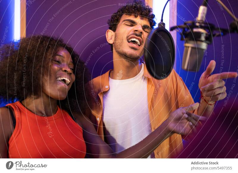 Mann und schwarze Frau singen und nehmen gemeinsam ein Lied auf Sängerin Aufzeichnen schreiben Musik Gesang hohe Note Mikrofon Atelier Punkt Afroamerikaner