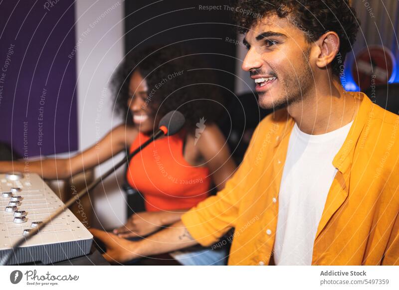 Mann und schwarze Frau beim Einstellen von Tonaufnahmen Audio Ingenieur Aufzeichnen Sänger Gesang Klang Musik Atelier ausrichten kreieren Afroamerikaner