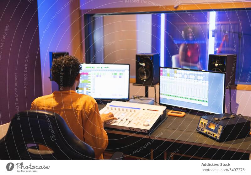 Mann nimmt Gesang im Studio auf Künstlerin singen Aufzeichnen Audio Ingenieur Klang Musik Atelier schwarz Afroamerikaner Sänger Stimme Techniker komponieren