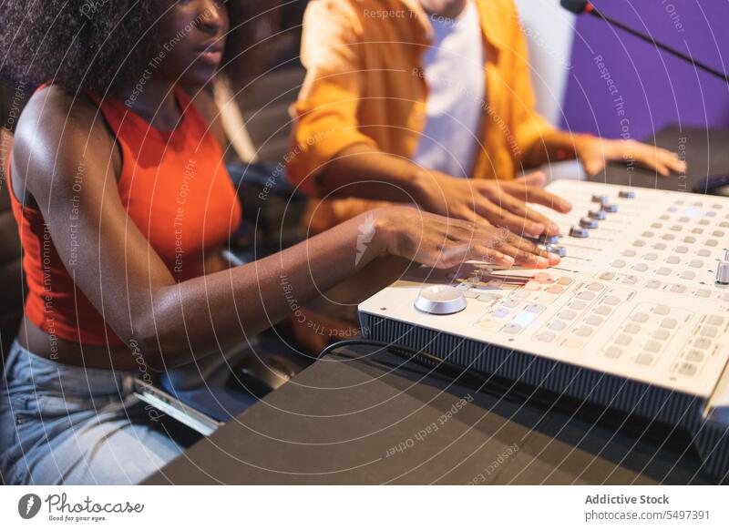 Anonyme und schwarze Frau beim Einstellen von Tonaufnahmen Audio Ingenieur Aufzeichnen Sänger Gesang Klang Musik Atelier ausrichten kreieren Afroamerikaner