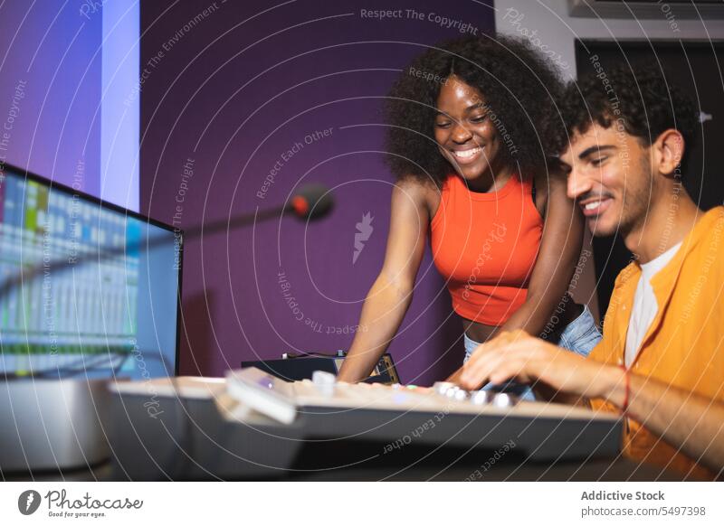 Mann und schwarze Frau beim Einstellen von Tonaufnahmen Audio Ingenieur Aufzeichnen Sänger Gesang Klang Musik Atelier ausrichten kreieren Afroamerikaner