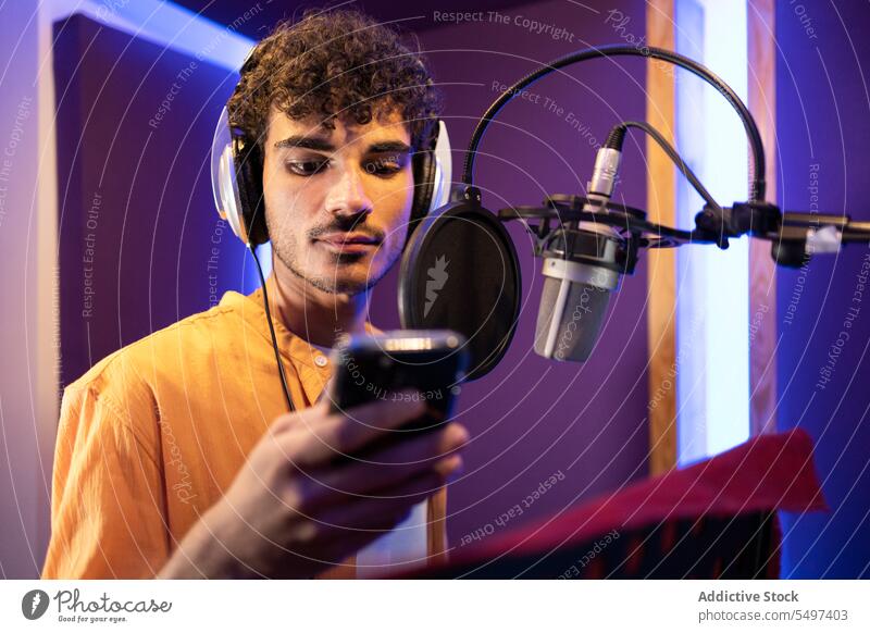 Mann überprüft erstellten Song auf Smartphone Sängerin zuhören Aufzeichnen Gesang Musik Atelier Klang männlich professionell Stimme Stern Musiker Künstlerin