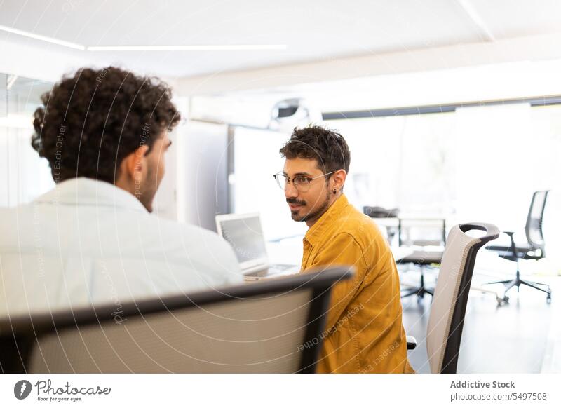 Männliche Kollegen arbeiten in einem modernen Büro zusammen Männer Laptop benutzend Projekt Arbeit Mitarbeiterin Arbeitsplatz männlich Job Business
