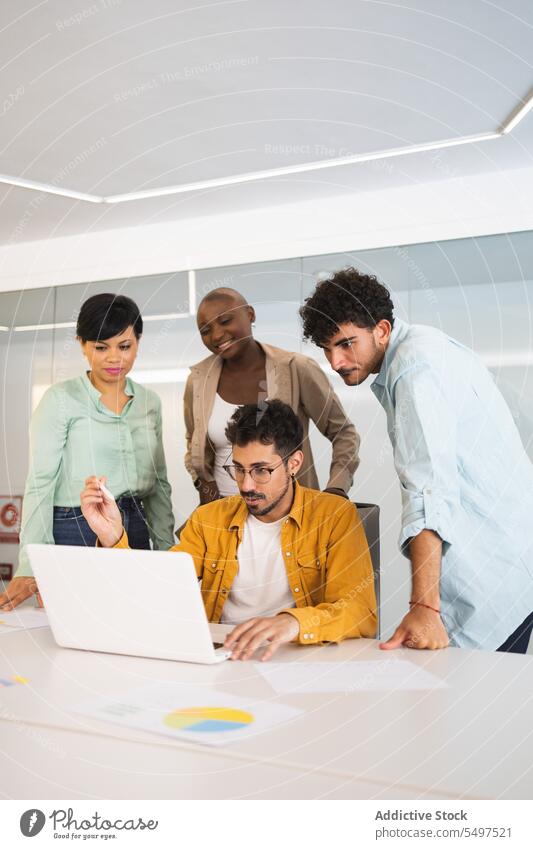 Verschiedene Kollegen arbeiten gemeinsam am Laptop Mitarbeiterin benutzend Arbeit Projekt Büro sich[Akk] sammeln Menschengruppe Business rassenübergreifend