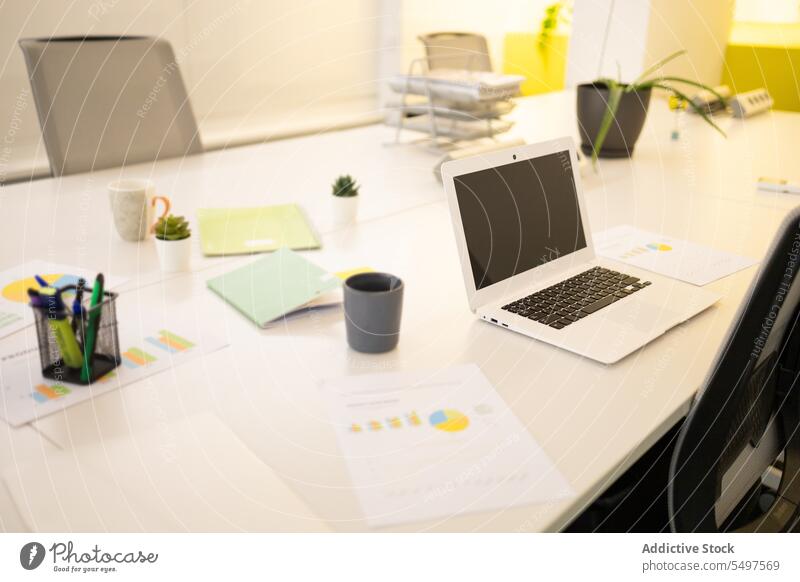 Laptop auf dem Schreibtisch in einem modernen Büro Arbeitsplatz Tasse Arbeitsbereich Kaffee Netbook Heißgetränk Gerät Apparatur Getränk Tisch Papier trinken