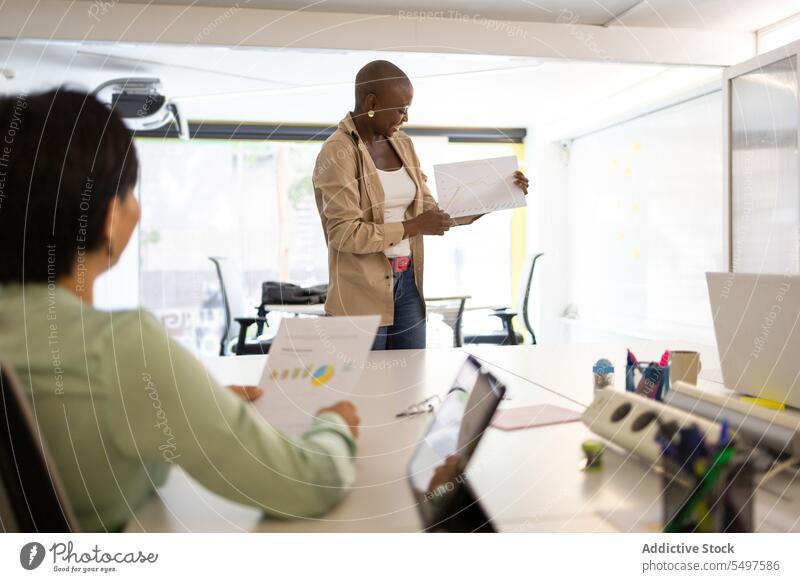 Ein Kollege hört eine schwarze Frau sprechen zeigen Papier Mitarbeiterin Büro Arbeit Arbeitsplatz teilen Sitzung professionell Business Arbeitsbereich