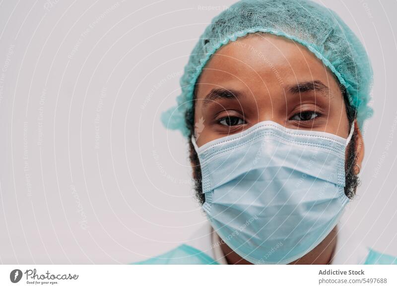 Ethnischer männlicher Chirurg schaut in die Kamera im Krankenhaus Mann Arzt professionell Spezialist ernst Klinik medizinisch Porträt Afroamerikaner Arbeit jung