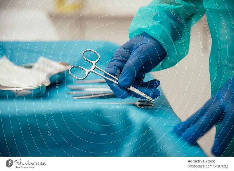 Ein Arzt ordnet die chirurgischen Instrumente auf dem Tisch vor der Operation an Mann Chirurg Chirurgie Werkzeug vorbereiten steril medizinisch Operationssaal