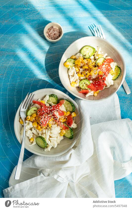 Gemüsemischsalat mit rohem Blumenkohl Salatbeilage Schalen & Schüsseln gesunde Ernährung Lebensmittel Sortimente Bestandteil lecker Gabel Gesundheit Tisch