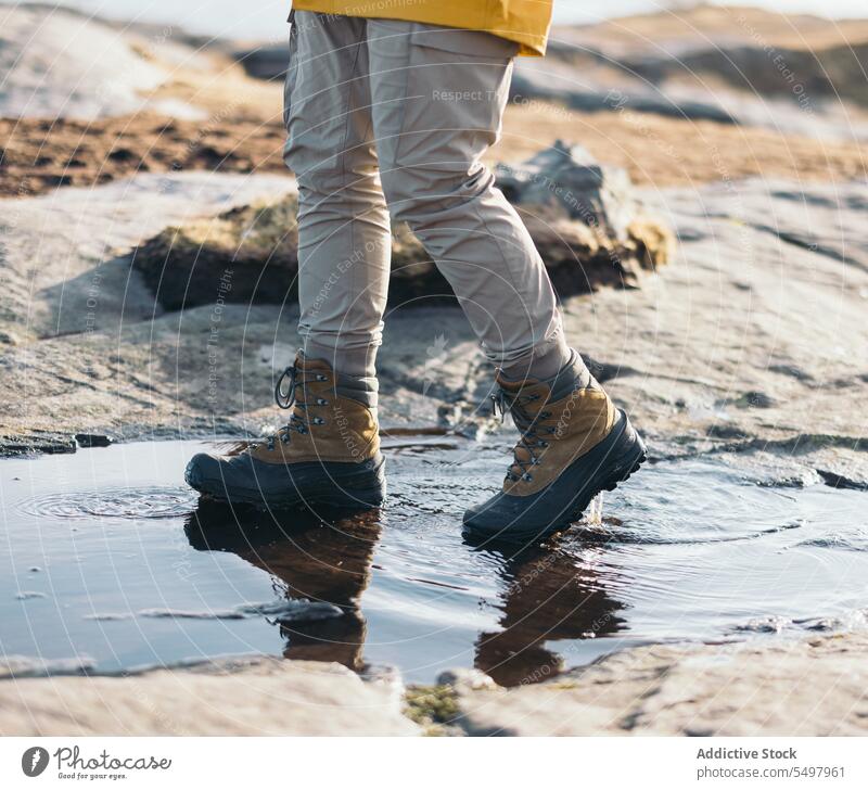 Crop Person geht auf Pfütze Spaziergang Stiefel Stein Schuhe rau Wasser Boden nass Umwelt Reflexion & Spiegelung Wetter natürlich Fuß Sonnenlicht reflektieren