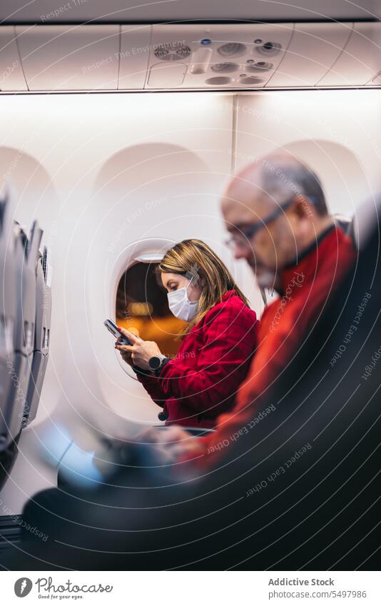 Menschen im Flugzeug sitzend, während sie auf eine touristische Reise gehen Passagier Tourist Sitz Fenster Flughafen Fluggerät warten Smartphone Lappland reisen