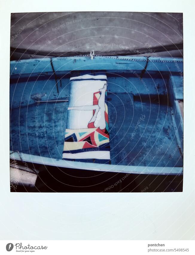 ein handtuch mit motiv in einem blauen boot. polaroid fischen beine 80er muster verblichen Wasser hafen urlaub reisen Sommer Polaroid vintage