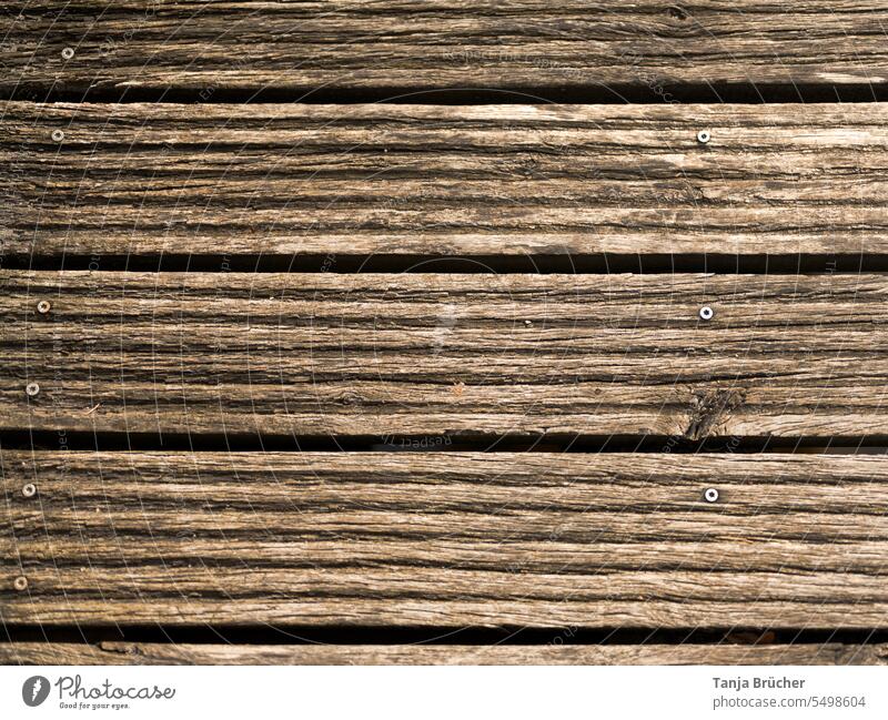 Geriffelte Holzdielen einer alten Holzbrücke Holzplanken Holzbohlen Holzbretter Profilbretter mit Nieten Schrauben Boden einer Holzbrücke verwittertes Holz