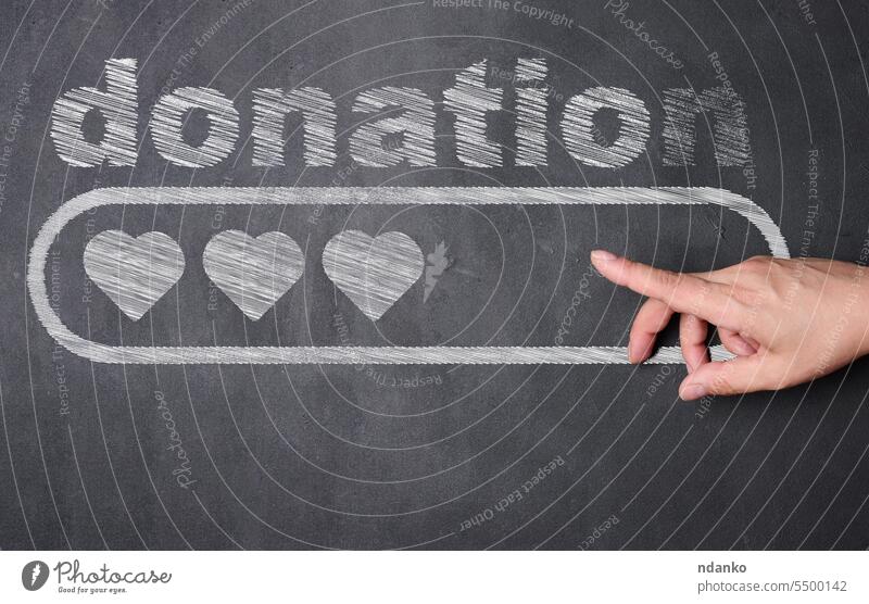 Eine Hand zeigt auf eine Tafel, auf der das Wort "Donat" steht, darunter ein rechteckiger Block mit drei Herzen darin Geldgeschenk schenken Liebe Spender Geben