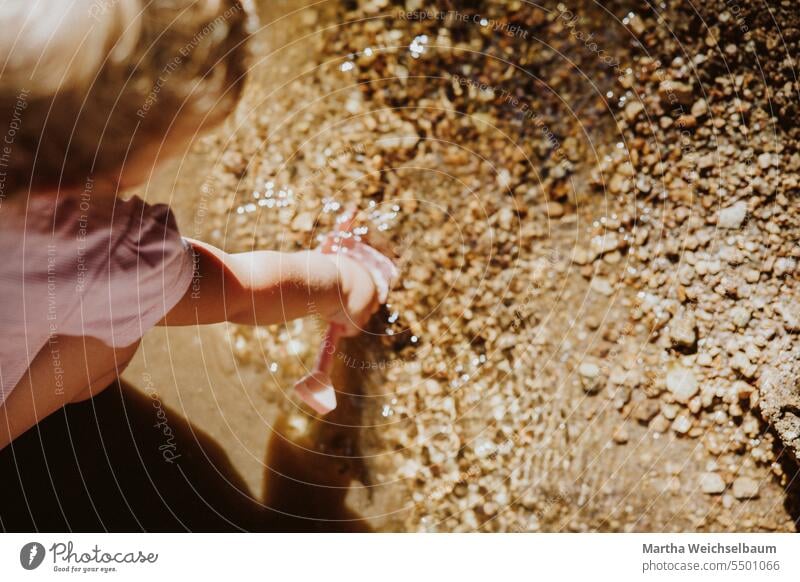 Kind spielt in Bach mit Sand und Kies Sandspiel Spielen im Freien spielen in der natur Spielen im Bach Natur Spielen mit Wasser Im Freien Sommer auf dem Land