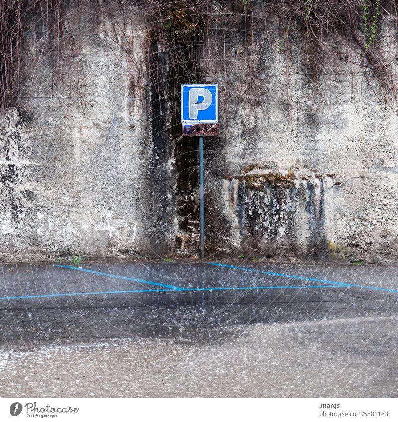 Verregnetes P Wand grau Mauer alt verwittert Schilder & Markierungen Hinweisschild Parkplatz Regen Asphalt trist schlechtes Wetter
