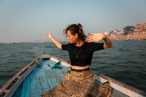 eine junge Frau sitz au einem Holzboot in Varanasi Boot fahren Wasser Wasserfahrzeug Ferien & Urlaub & Reisen Schifffahrt Farbfoto Außenaufnahme Tourismus