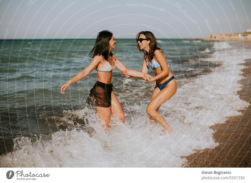 Zwei hübsche junge Frauen haben Spaß am Meer Erwachsener Strand schön Bikini sorgenfrei heiter genießen Genuss Freizeit Freunde Freundschaft Fröhlichkeit Glück