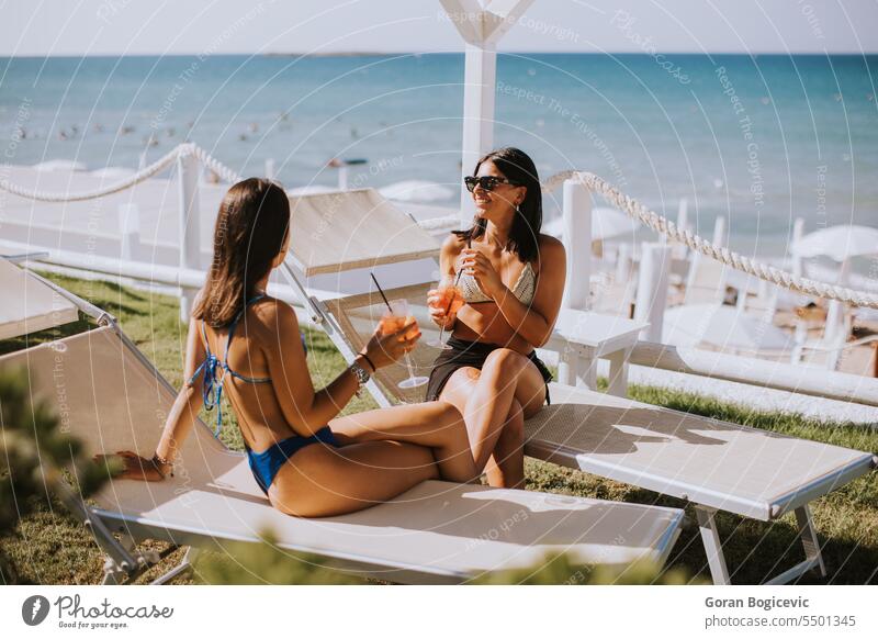 Lächelnde junge Frauen im Bikini genießen den Urlaub am Strand Glück Sonne Sonnenbrille attraktiv Menschen Lifestyle Freizeit Freundschaft Zusammensein