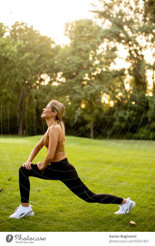 Hübsche junge Frau streckt sich im Park Körper aktiv Aktivität Erwachsener sportlich attraktiv schön Schönheit Windstille Übung passen Fitness Gras grün
