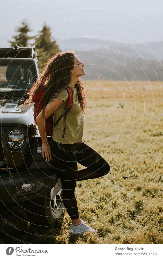 Junge Frau entspannt sich auf der Motorhaube eines Geländewagens auf dem Lande Erwachsener Abenteuer attraktiv Auto Automobil schön Pause Windstille PKW