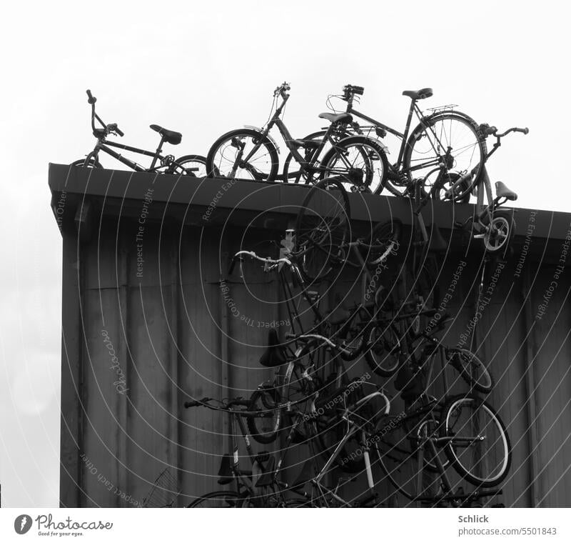 Viele Fahrräder als Deko auf und an einer Werkstatt aus Blech in schwarzweiss viele Schwarzweißfoto Metall Außenaufnahme niemand Dekoration Menschenleer Himmel