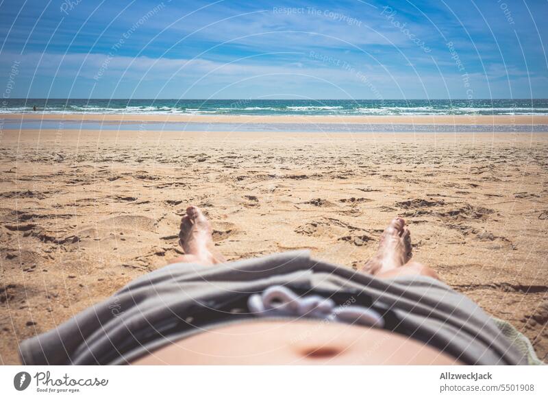 Kameraperspektive eines Mannes der am Strand liegt und zum Meer schaut pov Sommer Sommerurlaub Sommerzeit Wasser Sonnenbad sich sonnen liegend Zehenspitzen